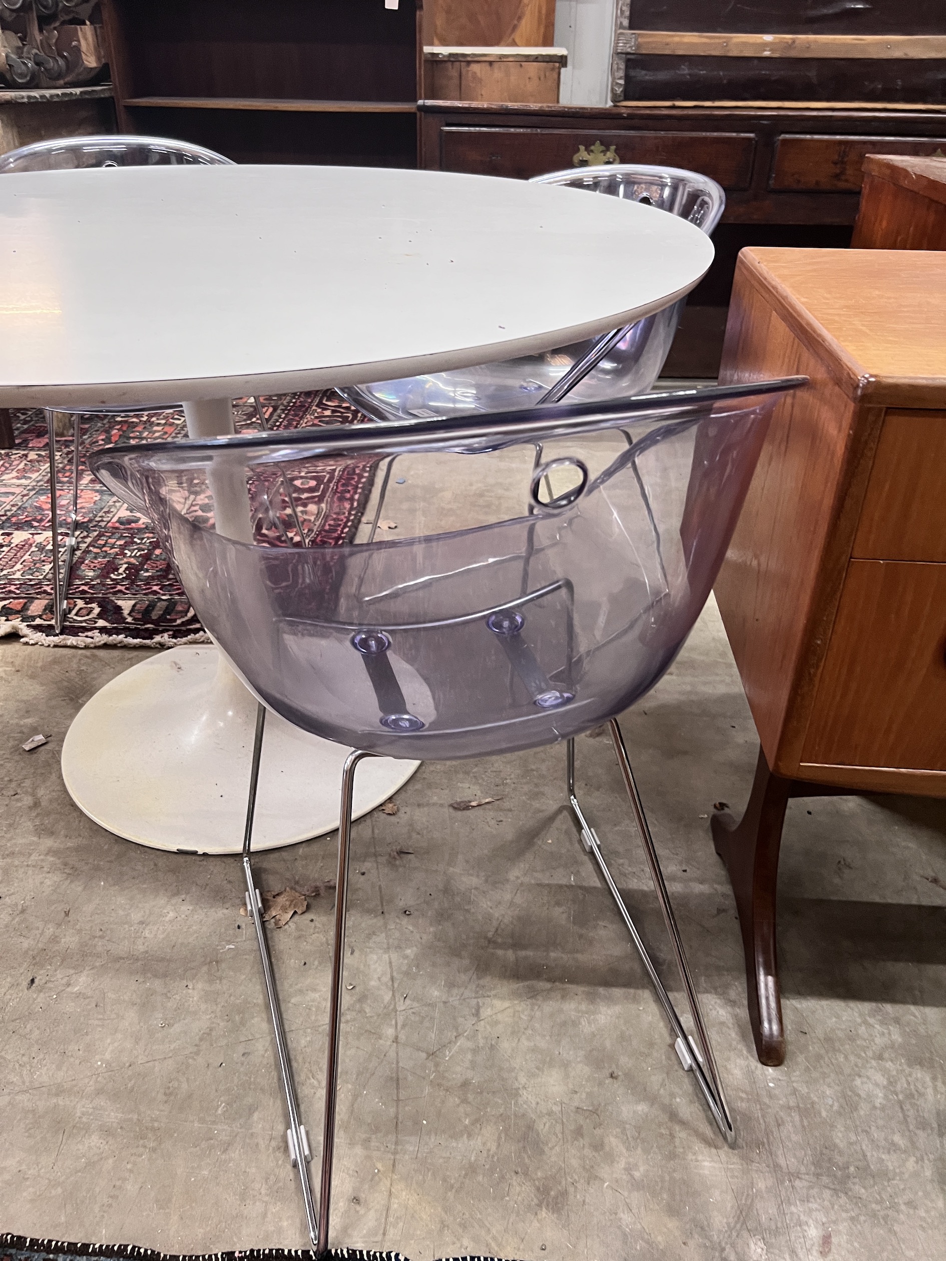 Three Habitat perspex armchairs and a Habitat ‘’Chelsea’’ circular white laminated wood table, diameter 120cm, height 72cm (3)